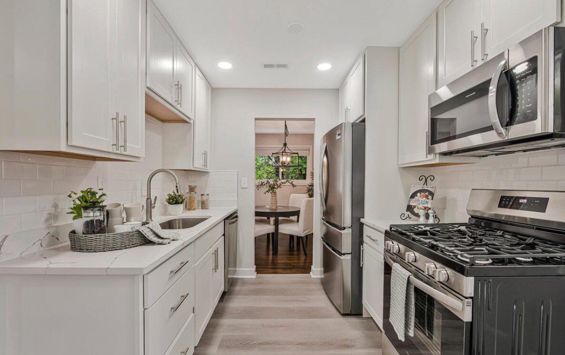 Bright modern white galley kitchen with stainless appliances